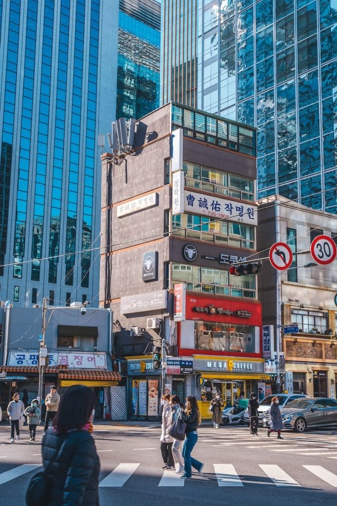 a group of people crossing a street in front of tall buildings