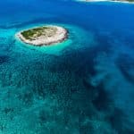 aerial view of green island in the middle of blue sea